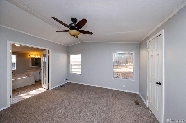 unfurnished bedroom featuring vaulted ceiling, ensuite bathroom, carpet floors, and ceiling fan