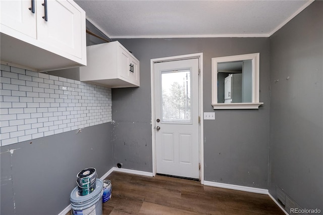 laundry room featuring crown molding and dark hardwood / wood-style flooring