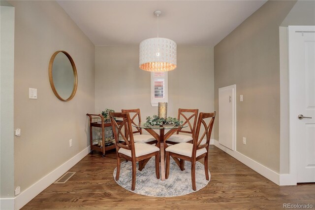 dining space featuring an inviting chandelier and dark wood-type flooring