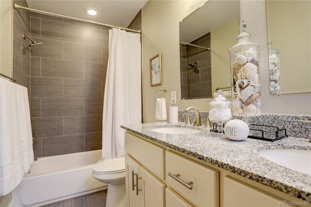 full bathroom with shower / tub combo with curtain, vanity, and toilet