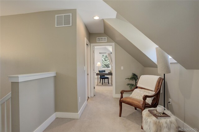 sitting room featuring vaulted ceiling and light colored carpet