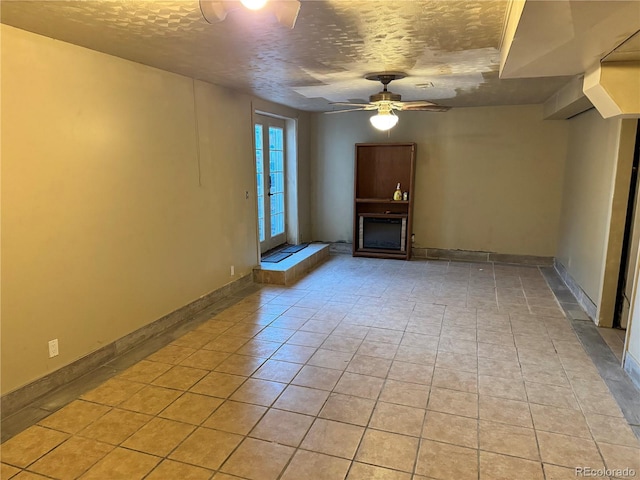 unfurnished living room featuring ceiling fan and a textured ceiling