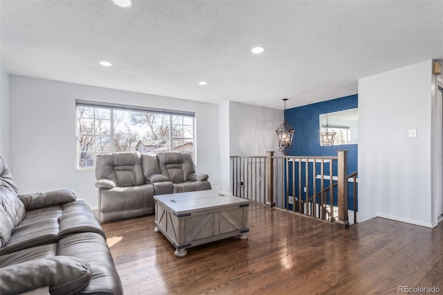 living room with a textured ceiling, baseboards, wood finished floors, and recessed lighting