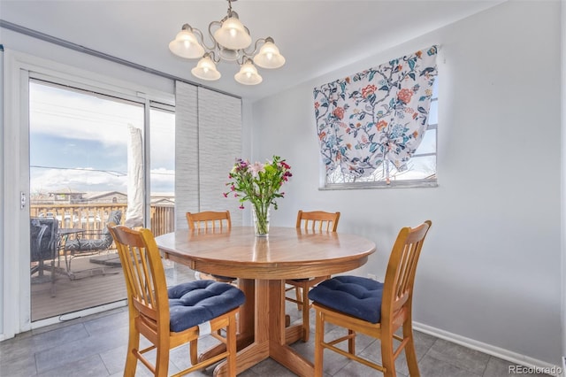 dining space with a chandelier, tile patterned flooring, plenty of natural light, and baseboards