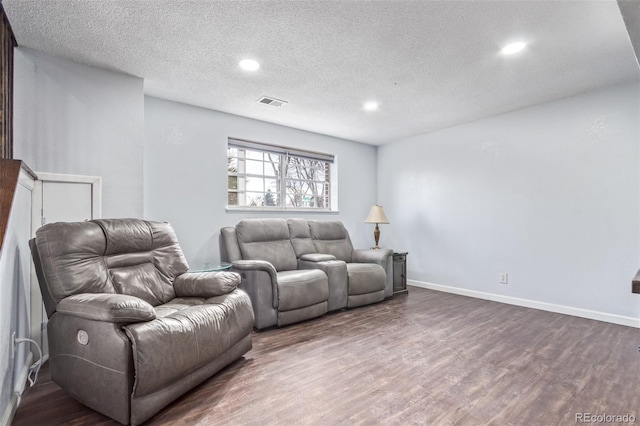 living room featuring recessed lighting, visible vents, dark wood-type flooring, a textured ceiling, and baseboards