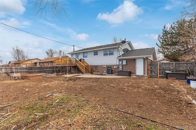 rear view of property featuring a garden, stairs, cooling unit, a patio area, and brick siding