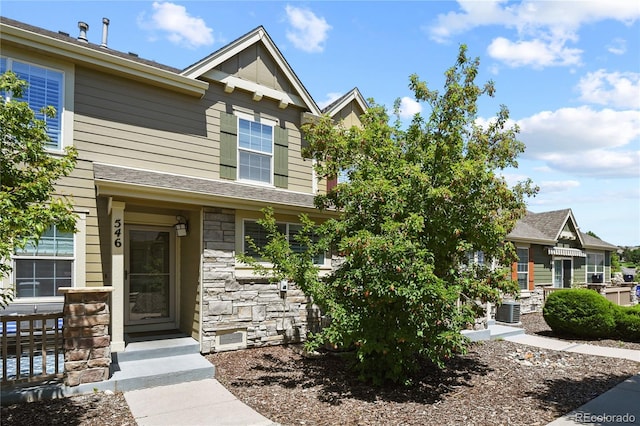 view of front facade featuring stone siding and central AC