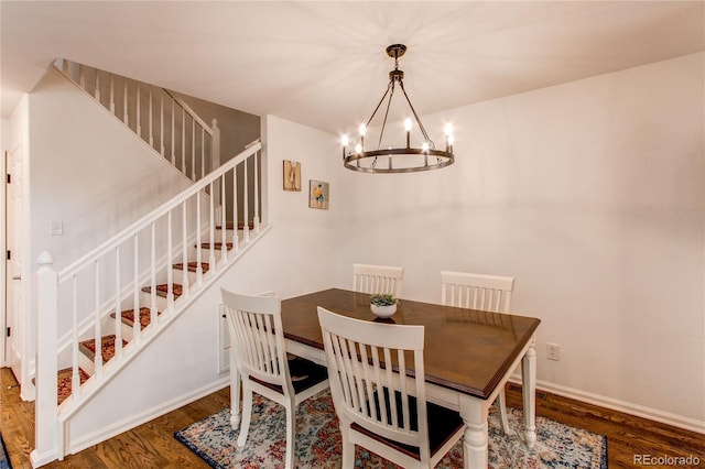 dining area featuring wood finished floors, a chandelier, stairway, and baseboards