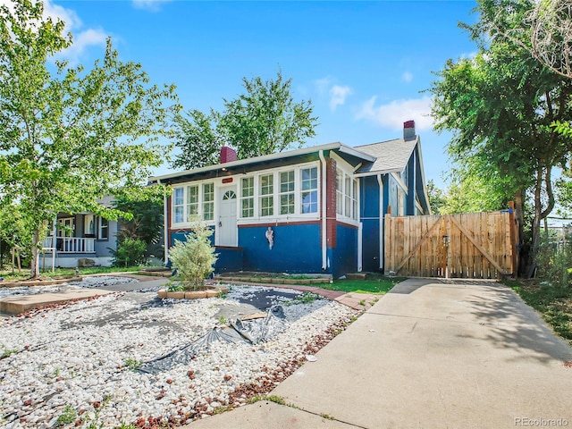 1561 Clinton St, Aurora, CO 80010 - view of front of home with a chimney and a gate
