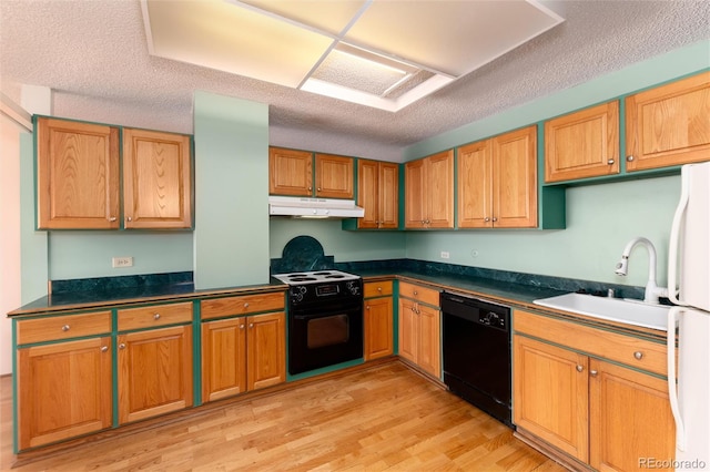 kitchen featuring sink, black appliances, a textured ceiling, and light hardwood / wood-style floors