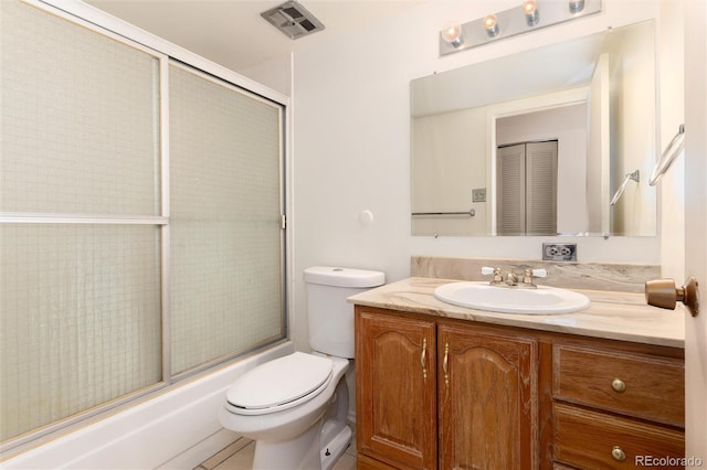 full bathroom featuring vanity, bath / shower combo with glass door, and toilet