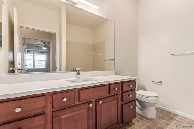 bathroom with toilet, vanity, and baseboards