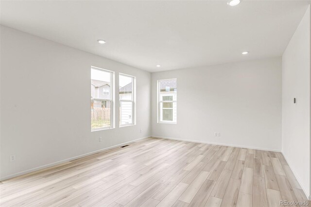 spare room with recessed lighting, light wood-type flooring, baseboards, and visible vents