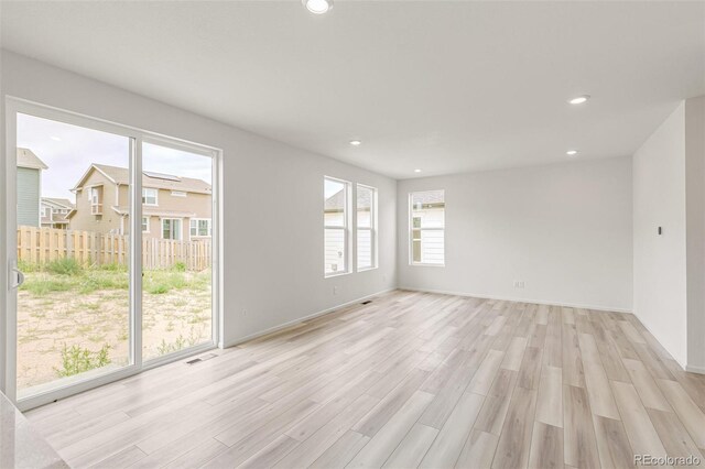 unfurnished room featuring visible vents, recessed lighting, light wood-type flooring, and baseboards