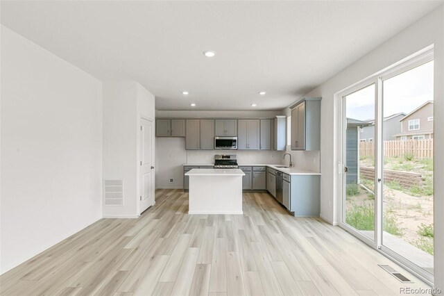 kitchen with visible vents, gray cabinets, plenty of natural light, stainless steel appliances, and a sink