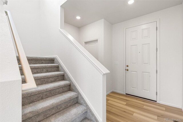 stairs featuring recessed lighting, wood finished floors, and baseboards