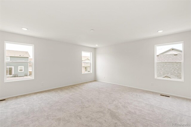 spare room with carpet flooring, recessed lighting, visible vents, and baseboards