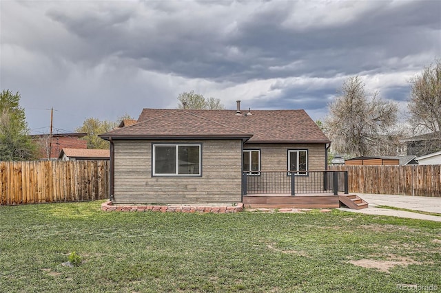 6000 Yarrow St, Arvada, CO 80004 - view of front of property featuring a wooden deck, a fenced backyard, roof with shingles, and a front lawn
