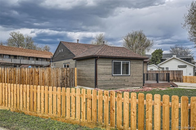 6000 Yarrow St, Arvada, CO 80004 - view of property exterior with a fenced backyard and a shingled roof