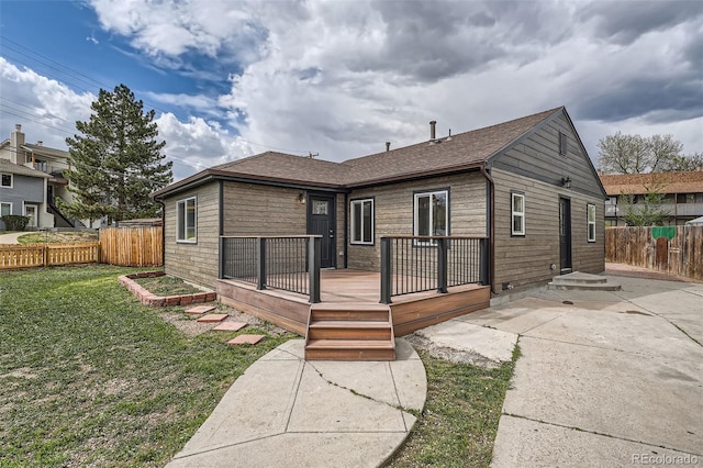 6000 Yarrow St, Arvada, CO 80004 - back of house featuring fence, a wooden deck, a patio, roof with shingles, and a yard