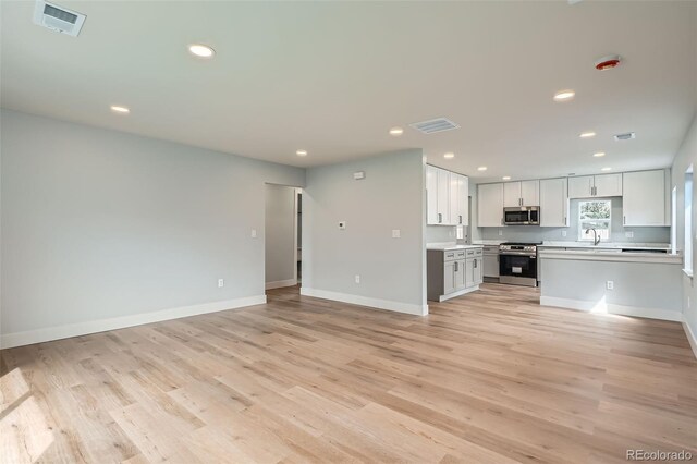 6000 Yarrow St, Arvada, CO 80004 - unfurnished living room with recessed lighting, visible vents, a sink, and light wood finished floors