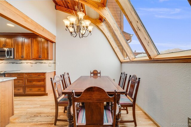 163 Ward Ct, Lakewood, CO 80228 - dining room with light wood-type flooring, a chandelier, and a skylight