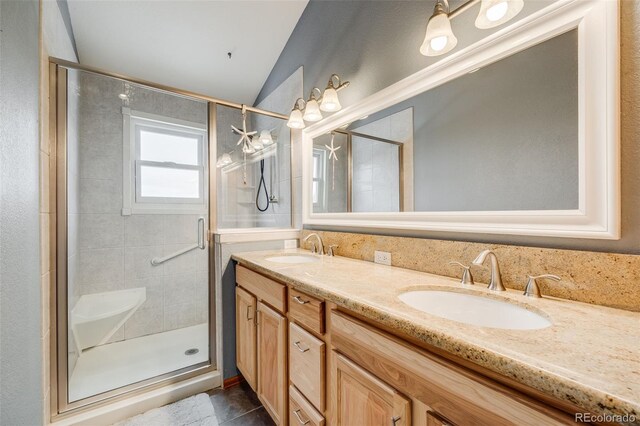 163 Ward Ct, Lakewood, CO 80228 - bathroom featuring double vanity, a stall shower, and vaulted ceiling