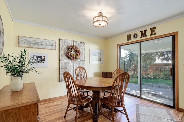 dining area featuring ornamental molding and light hardwood / wood-style floors