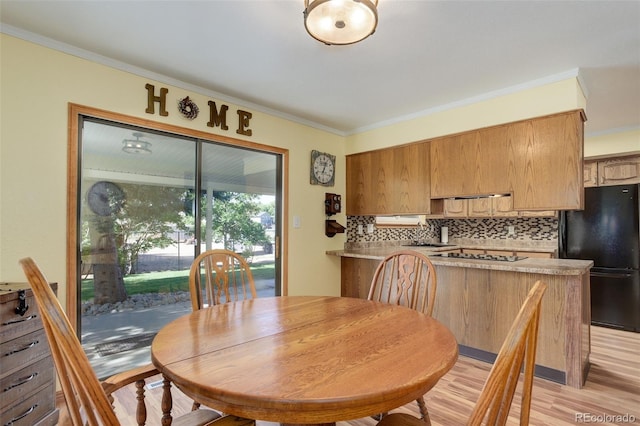 dining room featuring ornamental molding and light wood-type flooring