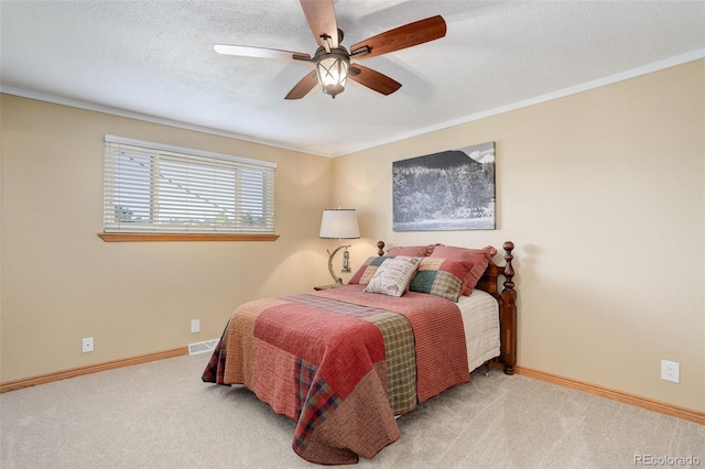 carpeted bedroom featuring ceiling fan, ornamental molding, and a textured ceiling