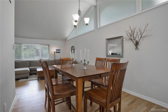 dining area featuring beamed ceiling, light hardwood / wood-style floors, high vaulted ceiling, and a notable chandelier