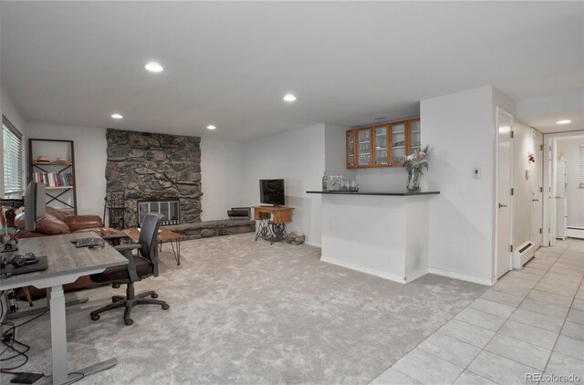 tiled office space featuring indoor bar, a stone fireplace, and a baseboard heating unit