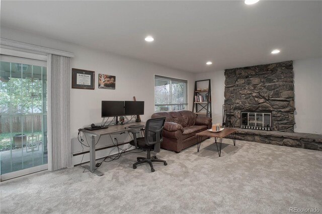 office space with a fireplace and light carpet