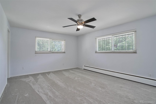 unfurnished room featuring ceiling fan, light carpet, a wealth of natural light, and a baseboard heating unit