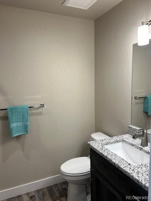 bathroom featuring vanity, toilet, and wood-type flooring