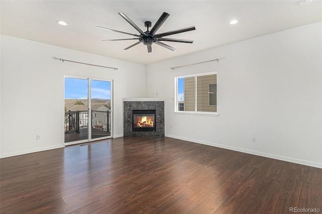 unfurnished living room with baseboards, wood finished floors, and a tile fireplace