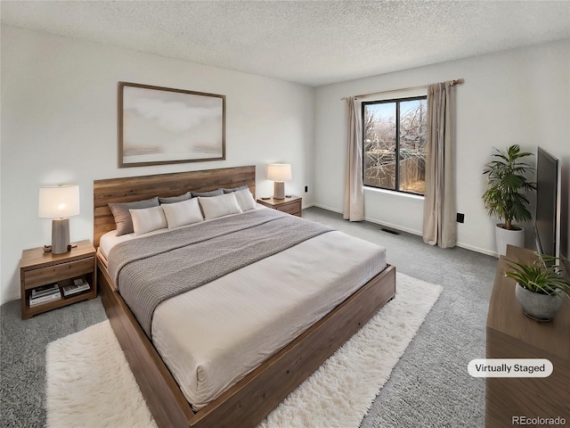 bedroom with carpet flooring, visible vents, baseboards, and a textured ceiling