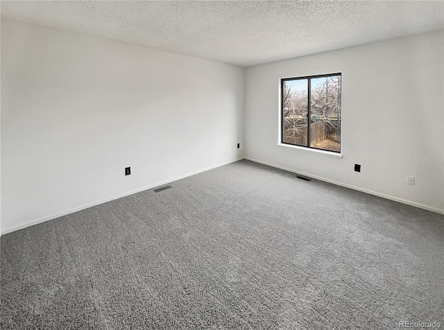 unfurnished room featuring visible vents, carpet floors, and baseboards