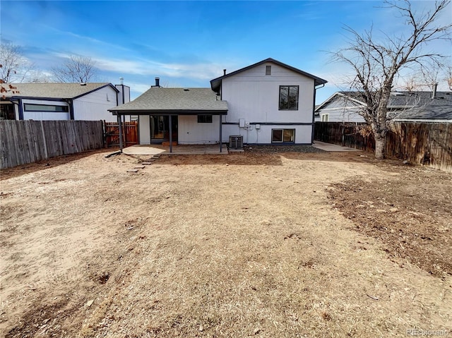 rear view of property featuring a patio, cooling unit, and a fenced backyard