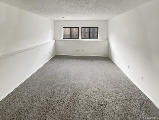 unfurnished room with visible vents, baseboards, a textured ceiling, and carpet flooring