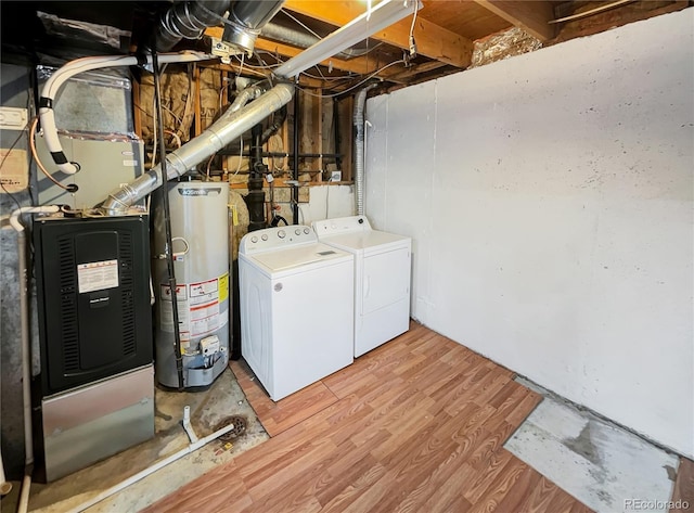 washroom featuring gas water heater, independent washer and dryer, laundry area, and light wood finished floors