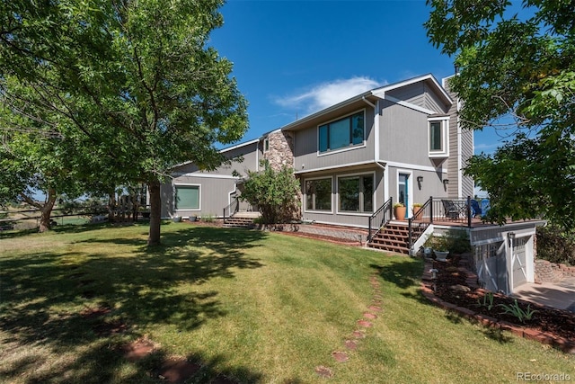 rear view of house with driveway and a lawn