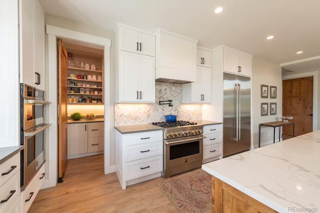 277 Hay Meadow Dr, Fraser, CO 80442 - kitchen featuring premium appliances, tasteful backsplash, light wood finished floors, light stone counters, and white cabinets