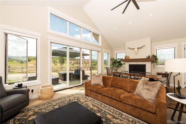 277 Hay Meadow Dr, Fraser, CO 80442 - living room with high vaulted ceiling, a glass covered fireplace, ceiling fan, wood finished floors, and baseboards