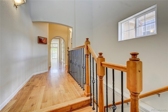 2061 Cheyenne Summer Vw, Colorado Springs, CO 80904 - hall featuring arched walkways, wood finished floors, an upstairs landing, baseboards, and a high ceiling