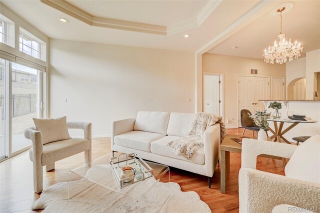 2061 Cheyenne Summer Vw, Colorado Springs, CO 80904 - living area featuring a chandelier, light wood-style floors, a raised ceiling, recessed lighting, and arched walkways