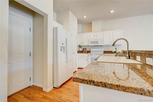 2061 Cheyenne Summer Vw, Colorado Springs, CO 80904 - kitchen with white appliances, light wood finished floors, a sink, white cabinetry, and light stone counters