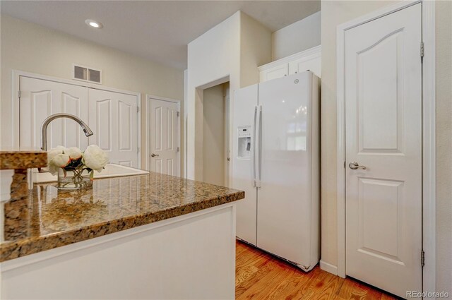 2061 Cheyenne Summer Vw, Colorado Springs, CO 80904 - kitchen featuring white refrigerator with ice dispenser, white cabinets, light wood-type flooring, stone countertops, and a sink