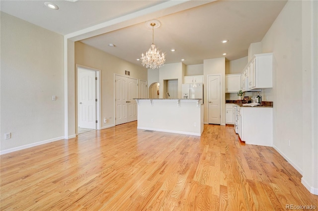 2061 Cheyenne Summer Vw, Colorado Springs, CO 80904 - kitchen with a chandelier, a kitchen bar, white fridge with ice dispenser, white cabinets, and recessed lighting