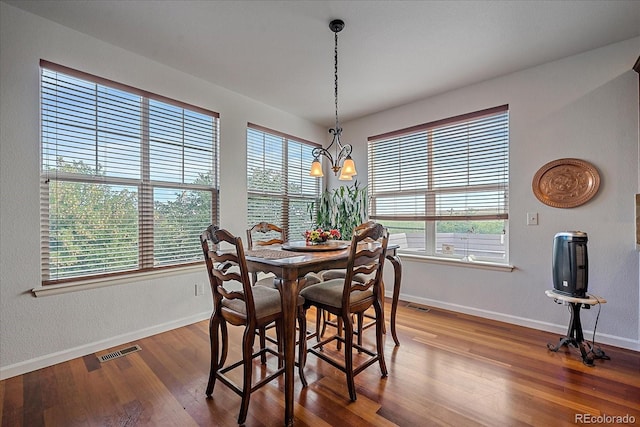 dining space with a wealth of natural light, a chandelier, and wood-type flooring